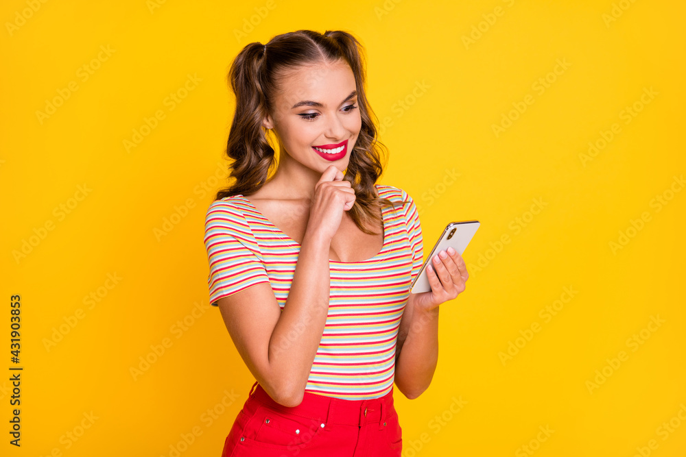 Photo of young beautiful attractive cheerful smiling positive girl blogger using smartphone isolated on yellow color background