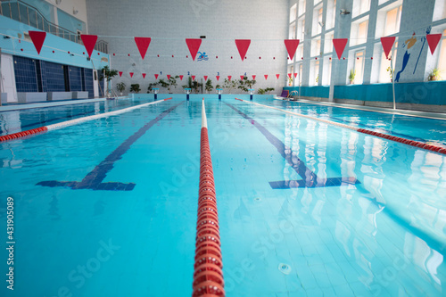 An empty sports pool with a red dividing path. Blue water in the swimming pool.