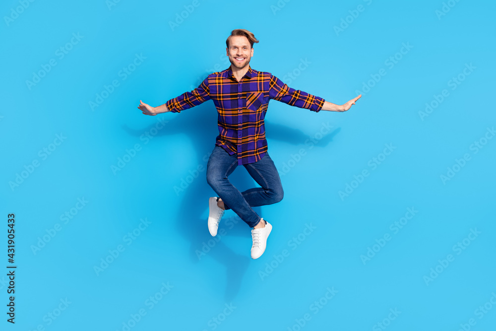 Full length body size view of attractive cheerful funny guy jumping posing isolated over vivid blue color background Full length body size view of attractive cheerful funny guy jumping posing isolated over vivid blue color background