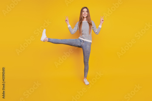 Portrait of friendly young lady stand one leg show v-signs