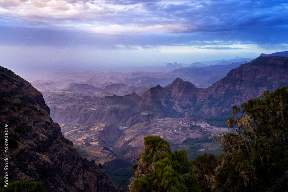 Simien landscape. twilight sunset in the rock in Simien Mountains NP, Ethiopia. Big hills in Africa. Pink landscape with hills and valleys with dark clouds.  Magic evening in Ethiopia nature.
