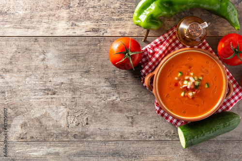 Gazpacho soup in crock pot and ingredient on wooden table. Top view. Copy space