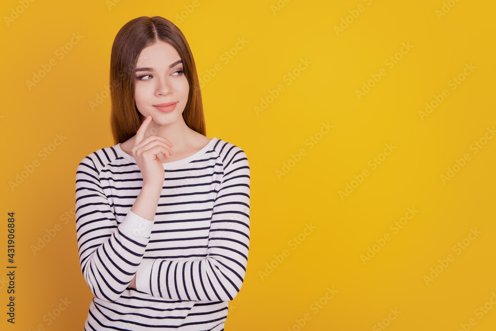 Portrait of minded lady finger chin look empty space on yellow background Portrait of minded lady finger chin look empty space on yellow background