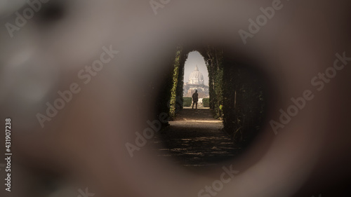Photography The dome of Saint Peter Basilica and a walking man seen through the famous keyho