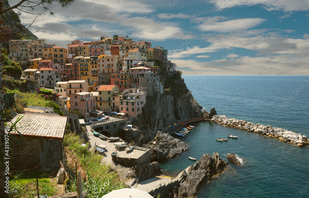 Manarola, Liguria, Italy. June 2020. Amazing view of the seaside village. The colored houses leaning on the rock near the sea are particularly fascinating and characteristic. Beautiful summer day.