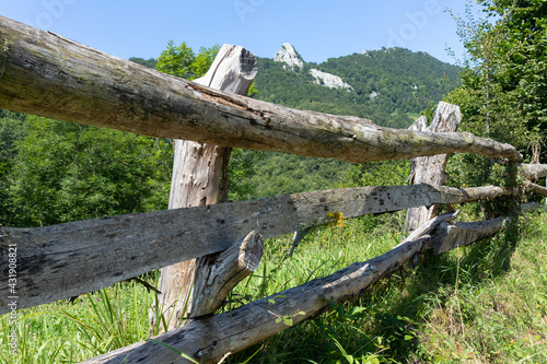 A path in the mountains covered with forests and meadows with wooden fences in the Spanish region of Asturias, Caleao village, in the Redes Natural Park, Biosphere Reserve since 2001