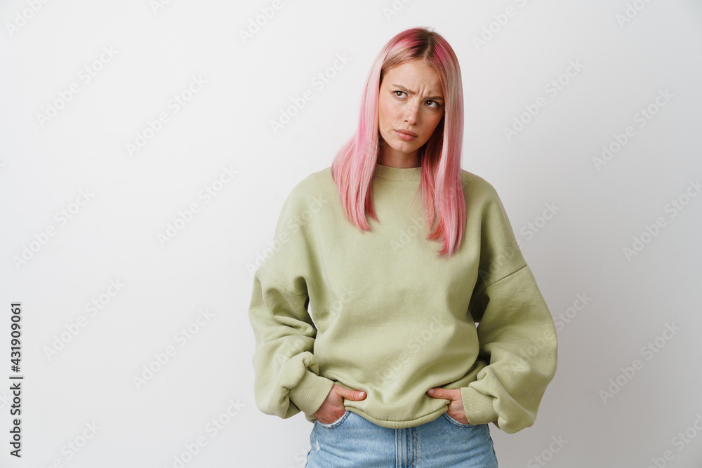 Young displeased woman with pink hair frowning and looking aside Young displeased woman with pink hair frowning and looking aside