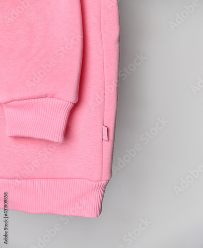 Close up of baby pink sweatshirt hoodie with label.