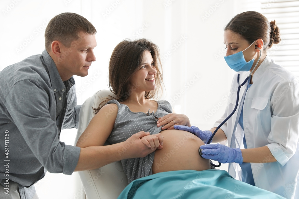 Doctor examining woman before giving child birth in maternity hospital Doctor examining woman before giving child birth in maternity hospital