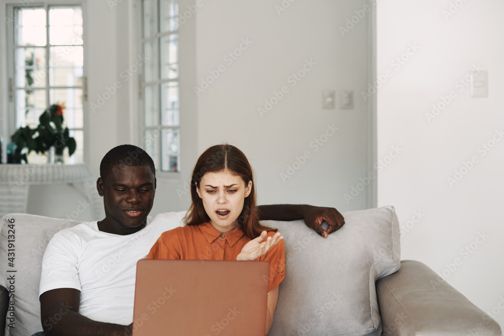 man and woman at home on the couch in front of laptop communication man and woman at home on the couch in front of laptop communication
