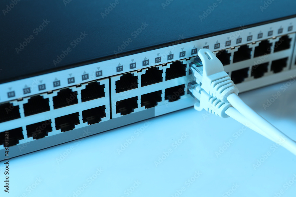 Closeup view of network switch with cables on light background, toned in blue. Internet connection Closeup view of network switch with cables on light background, toned in blue. Internet connection