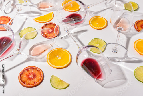 glasses of wine on a white table with sliced citrus fruits