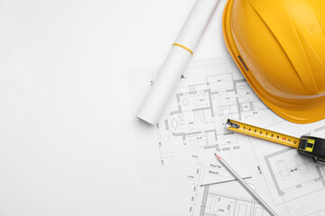 Flat lay composition with blueprints and hardhat on white background. Space for text