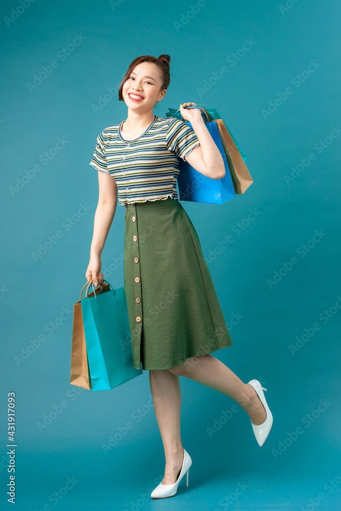 Woman wearing casual sweater on background happy enjoying shopping holding colorful bags Woman wearing casual sweater on background happy enjoying shopping holding colorful bags