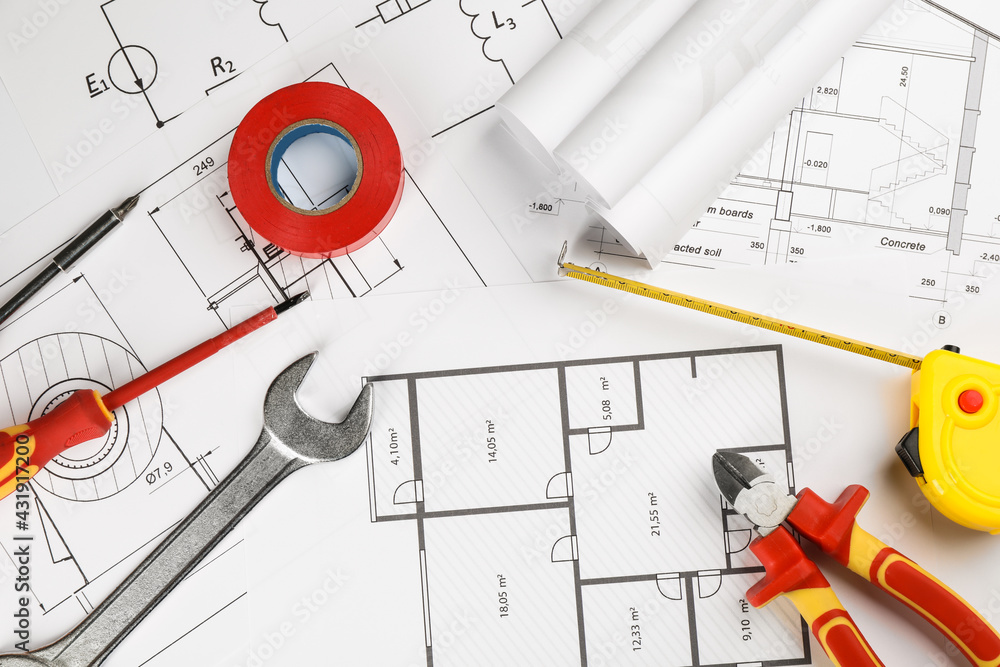 Flat lay composition with electrician's tools on house plan sheets
