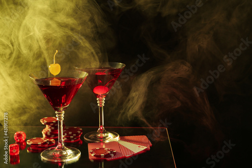 Photography Casino chips, dice, playing cards and cocktails on dark background with smoke, s