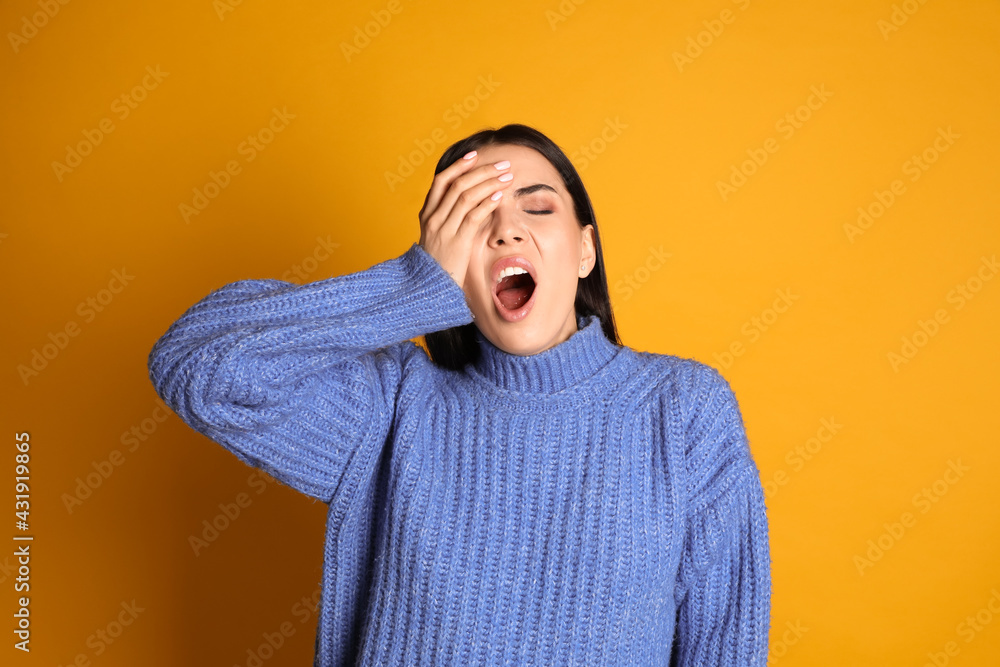 Young tired woman yawning on yellow background Young tired woman yawning on yellow background