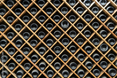Wine bottles background. Bottles of red and white wine in a wine cabinet of a liquor store