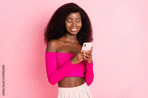Photo of charming lady hold telephone beaming smile wear top unclothed shoulders isolated pink color background