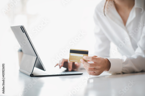 Woman hand using laptop Mockup and credit card for shopping payment online at home.E-commerce and online shopping concept,