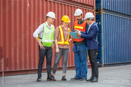Foreman and secretary clipboard meeting with worker to checking control loading Containers box at warehouse logistic in Cargo freight ship for import export in harbor. shipping in docks.