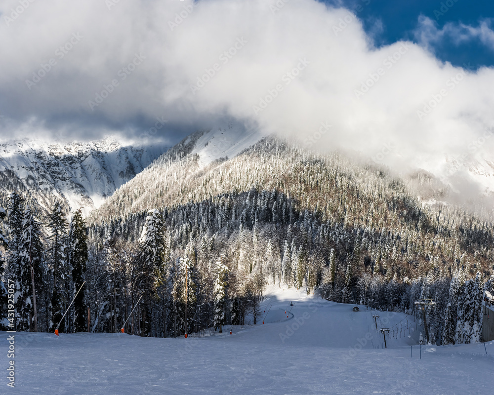 Ski slope against Caucasus mountains covered by pine forest. Ski slope against Caucasus mountains covered by pine forest.