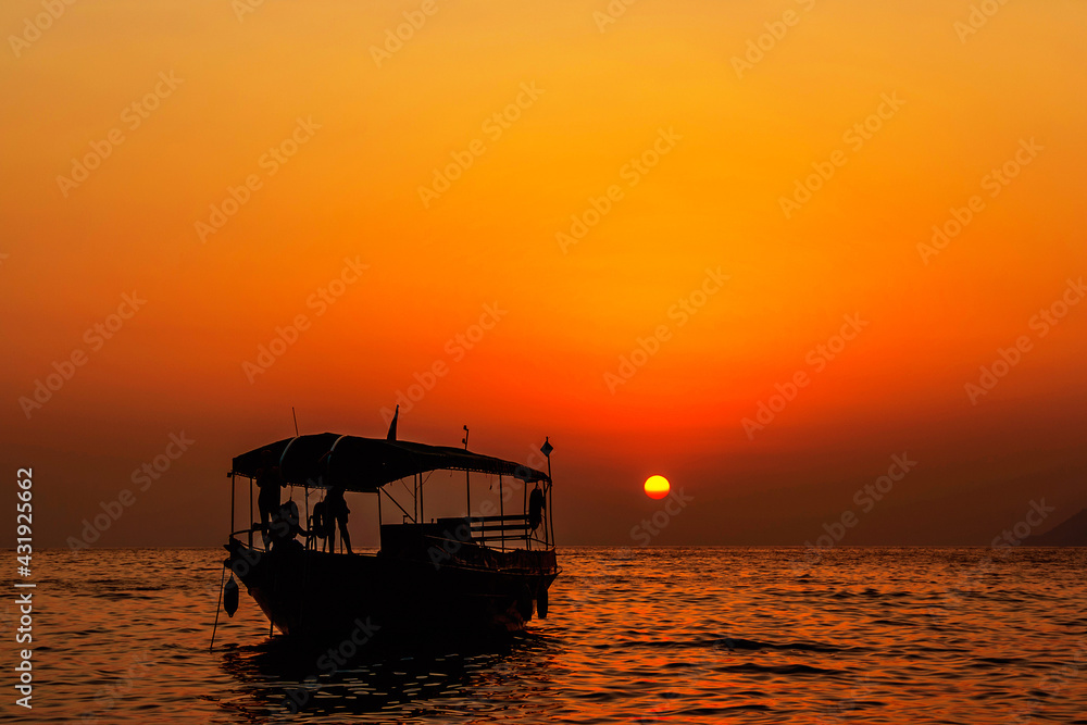 boat and a beautiful sunset at the sea on a summer evening
