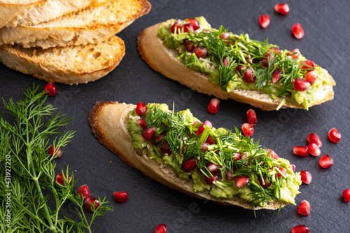 delicious avocado canapes sprinkled with ripe pomegranate seeds, sesame seeds and fragrant fresh dill