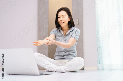 Free Download パソコンを見ながら軽い運動をする女性（40代、50代イメージ） - GFXLoad