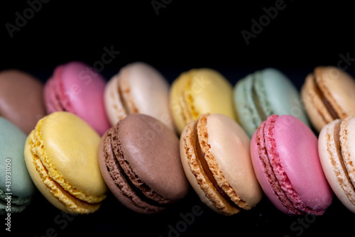 macaroons of different colors on a black background