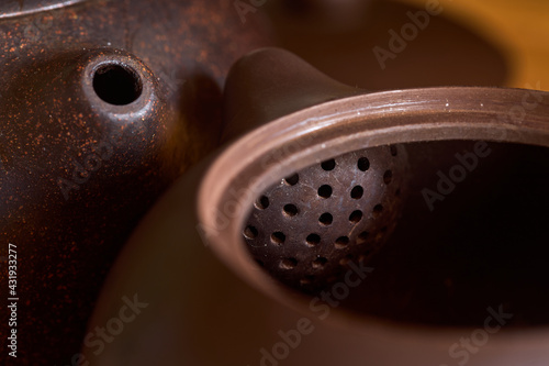Chinese tea ceremony gong fu cha. Selective focus. Two handmade purple yixing zisha clay chinese teapots for shu pu erh red tea black tea or oolong brewing with open lid and clay ball filter inside. photo