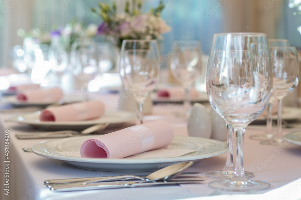 Close up of wedding dinning table set up with white round plates and pink napkins Close up of wedding dinning table set up with white round plates and pink napkins