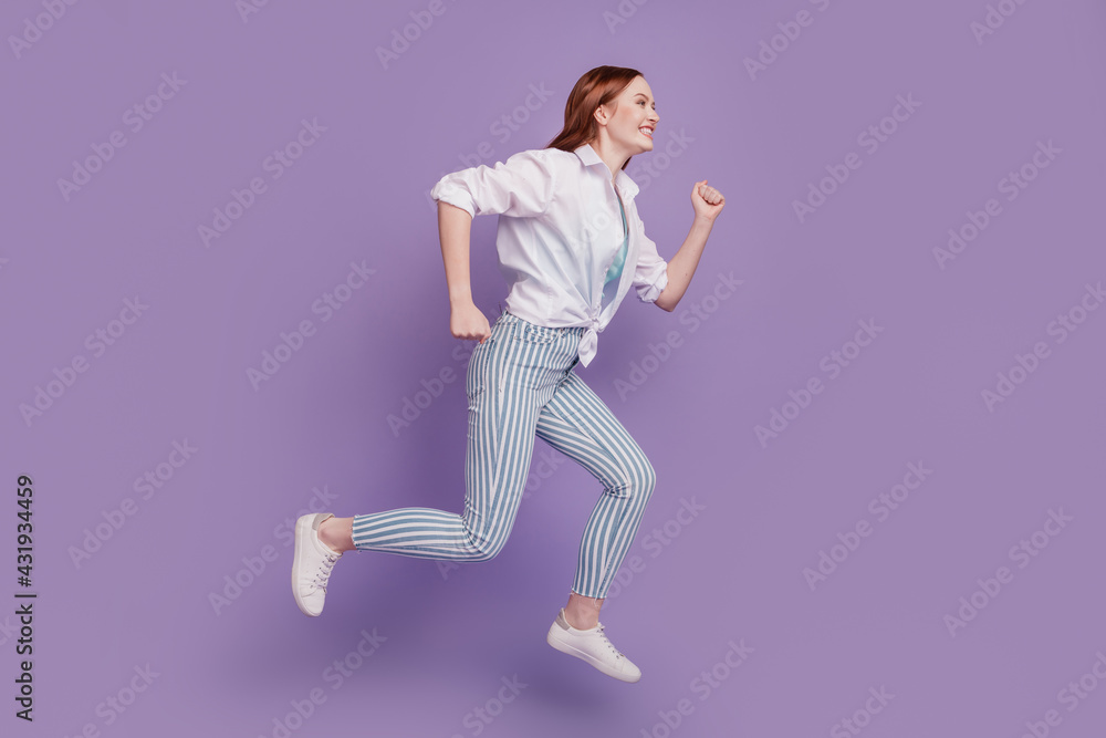 Portrait of sportive energetic lady jump run copyspace on purple background