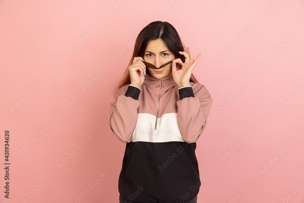 Young woman's portrait on pink studio background. Concept of human emotions, facial expression, youth, sales, ad. Young woman's portrait on pink studio background. Concept of human emotions, facial expression, youth, sales, ad.