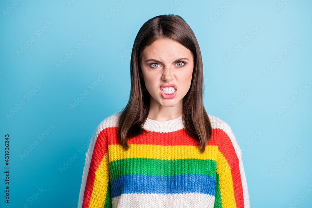 Photo of angry furious young girl dressed colorful clothes showing teeth isolated blue color background Photo of angry furious young girl dressed colorful clothes showing teeth isolated blue color background
