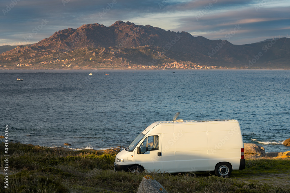 Camper van motorhome with solar panels view on a sea landscape with mountains living van life in Galiza, Spain Camper van motorhome with solar panels view on a sea landscape with mountains living van life in Galiza, Spain