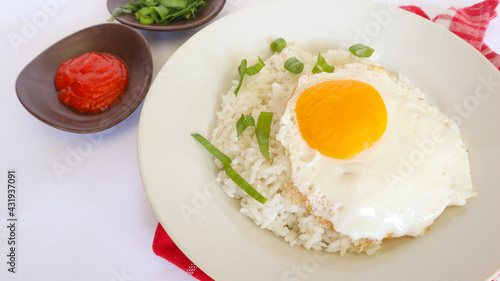 fried egg rice. breakfast fried egg sunny side rice on a plate, isolated on white background
