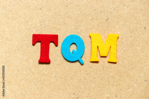 Color cloth alphabet letter in word TQM (Abbreviation of total quality management) on wood background
