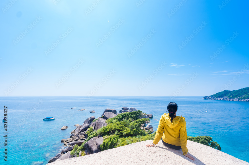 woman girl with yellow shirt sitting on the rock at similan island in Thailand.sea beach.Sea view from tropical beach with sunny sky.Summer beach island.Exotic summer with clouds.relax hope background