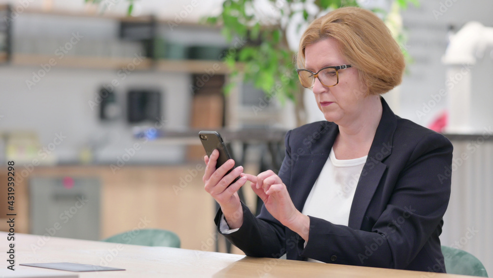 Obraz premium Serious Businesswoman using Smartphone in Office