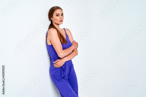 Young beautiful woman posing in new casual blue fashion costume dress with pants full body on white background