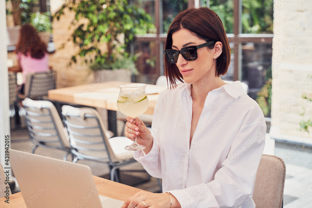 Pritty business woman in glasses drinking cocktail - obrazy, fototapety, plakaty 