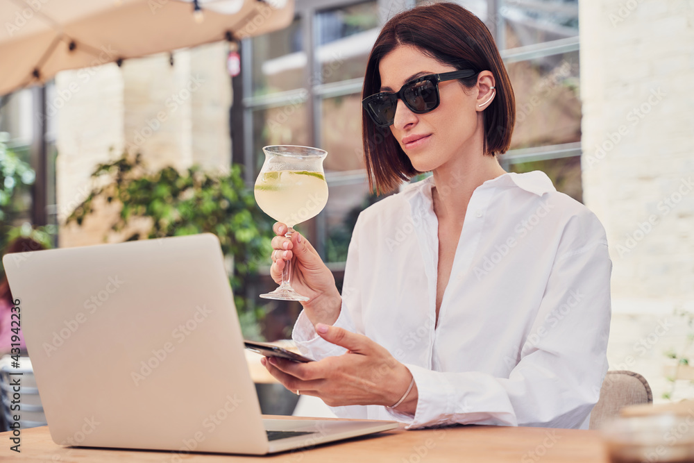 Pritty business woman in glasses drinking cocktail - obrazy, fototapety, plakaty 