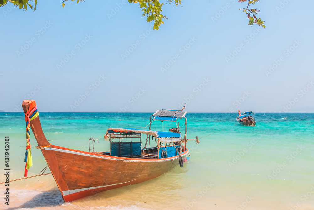 A colourful traditional Thai long-tail fishing boat on the sandy tropical beach of Koh Phi Phi, Thailand.