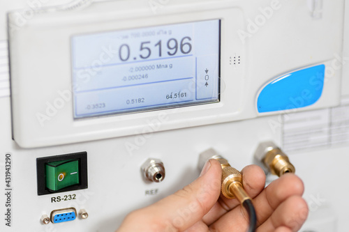 The metrology and standardization laboratory specialist connects the device under test pressure gauge to the pressure calibration and verification instrument. Checking the pressure value photo