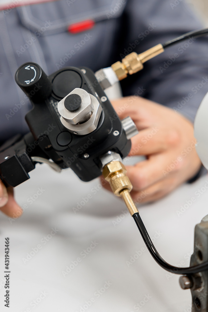 Obraz premium The metrology and standardization laboratory specialist connects the device under test pressure gauge to the pressure calibration and verification instrument. Checking international quality standards