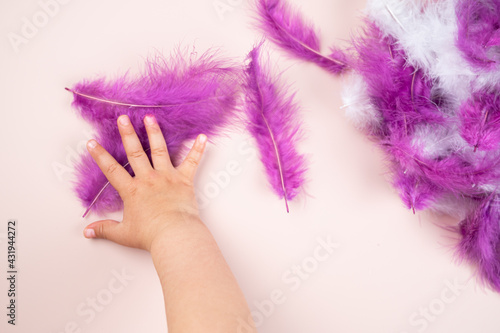 Multi-colored feathers in the hand of a child