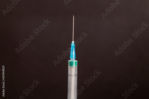Disposable syringe with needleon a black background.