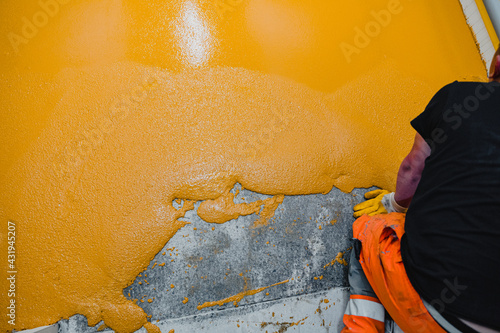 Worker applying epoxy and polyurethane flooring system photo