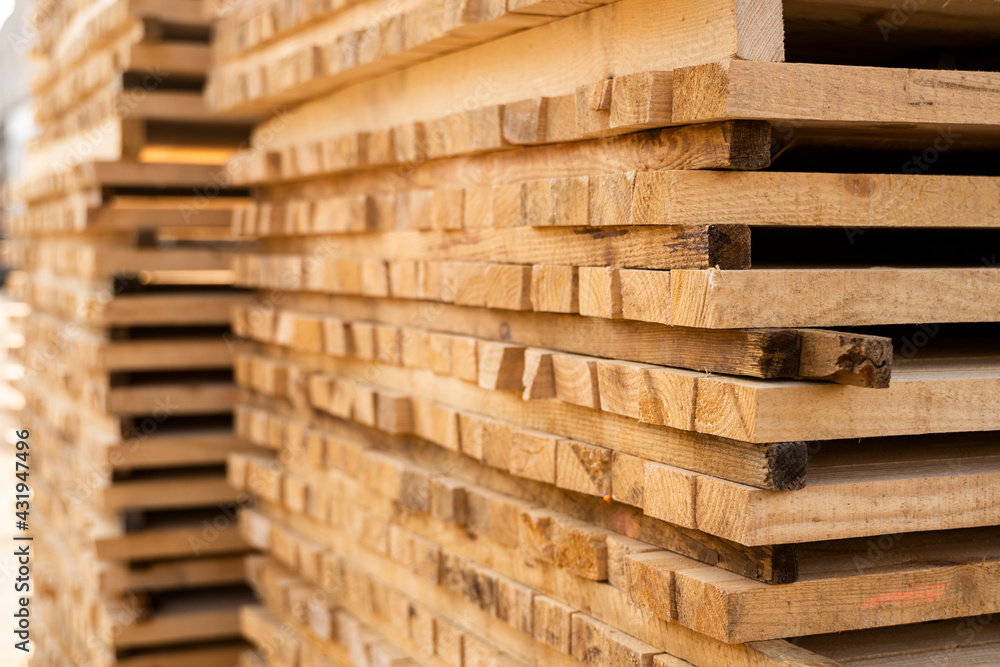 Storage of piles of wooden boards on the sawmill. Boards are stacked in a carpentry shop. Sawing drying and marketing of wood. Pine lumber for furniture production, construction. Lumber Industry.